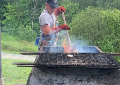 photo of man working on a large fire grill