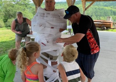 photo of family wrapping dad in toilet paper